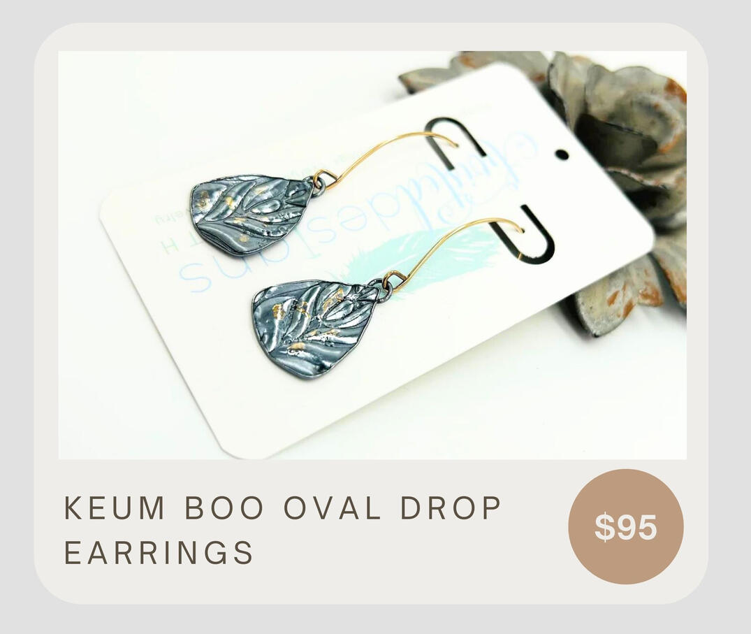 The Keum Boo Oval Drop earrings feature a 14k gold filled ear wire, fine silver roller printed oval dangle, textured look, and a 24k gold overlay.